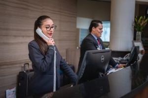 Two receptionists at their computers on the phone